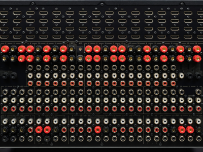 Back panel of a complex AV receiver showing numerous HDMI, speaker terminal, and RCA connections